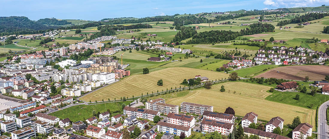 Luftaufnahme von Zug mit angrenzender Wohnsiedlung und weitläufigem Grünraum in der Nähe des Neubauprojekts Colin.
